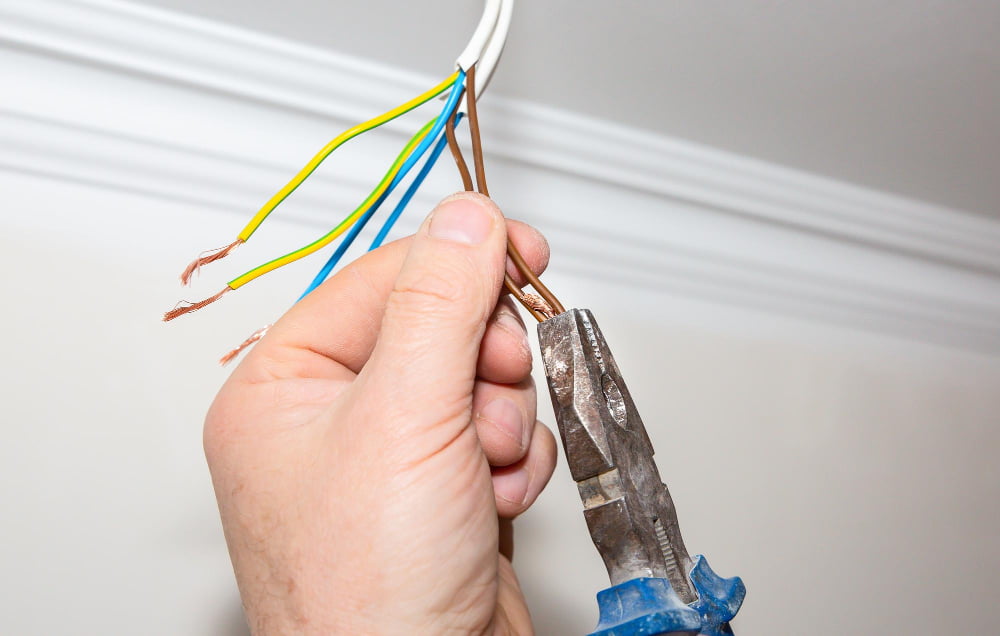 man using wire stripper tool